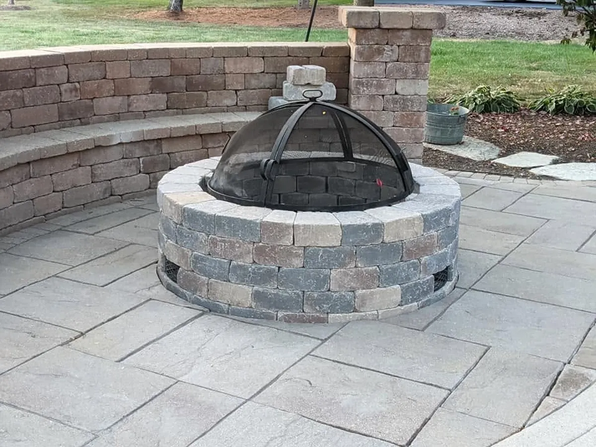 Outdoor stone fireplace installation in a backyard