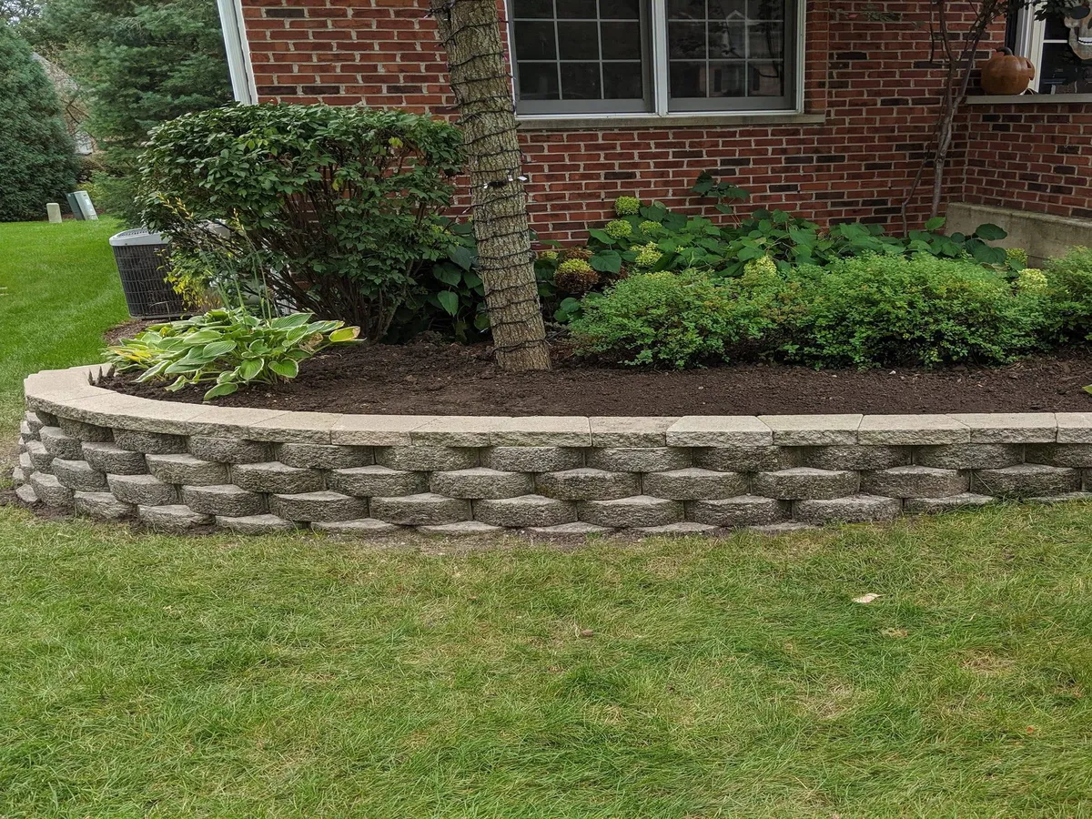 Stone retaining wall built in four levels on a sloped yard